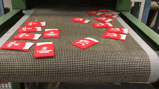 Printed silicone phone wallets exiting a drying oven